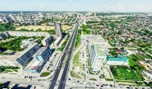 Vista aérea de la ciudad con encrucijadas y caminos, casas, edificios, parques y estacionamientos. Imagen panorámica soleada de verano —  Fotos de Stock