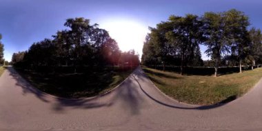 Bir şehir parkının UHD 4K 360 VR Sanal Gerçekliği. Sonbaharda ya da yaz gününde ağaçlar ve yeşil çimenler