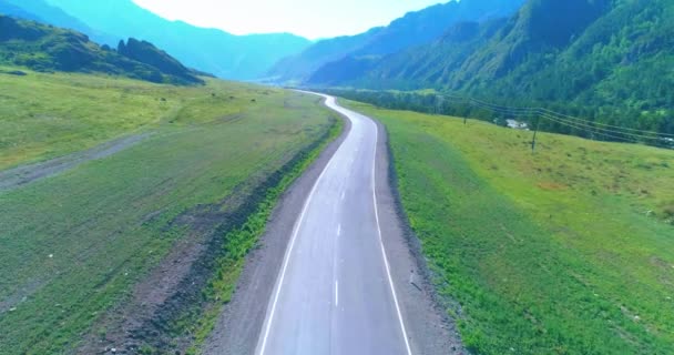 Vuelo sobre carretera asfaltada montaña carretera y prado — Vídeo de stock