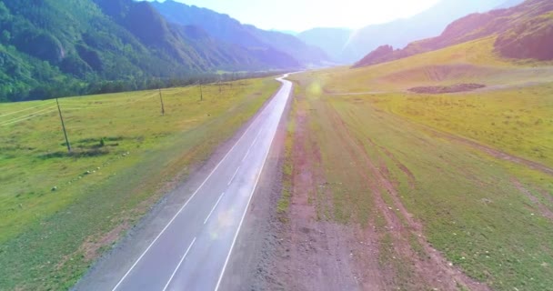 Vuelo sobre carretera asfaltada montaña carretera y prado — Vídeo de stock