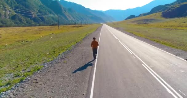 Volo a bassa quota di fronte all'uomo sportivo in perfetta strada asfaltata — Video Stock