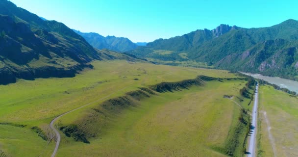 Aerea strada di montagna rurale e prato al sole mattina d'estate. Autostrada asfaltata e fiume. — Video Stock