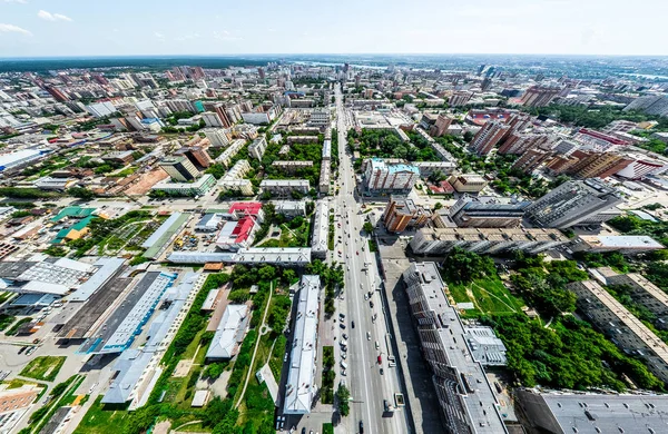 Vista aérea de la ciudad con encrucijadas y caminos, casas, edificios, parques y estacionamientos. Imagen panorámica soleada de verano — Foto de Stock