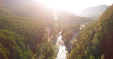 Güneşli yaz sabahında taze dağ nehri ve çayır üzerinde uçuşun ortasında. Aşağıdaki kırsal toprak yol.