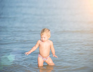 Şirin Bebek kumlu plajı ve deniz suyu oynarken.