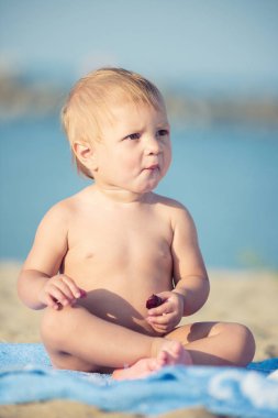 Şirin Bebek denize yakın kum plajındaki oyuncaklar ile oynama.