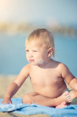Şirin Bebek denize yakın kum plajındaki oyuncaklar ile oynama.