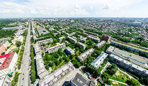 Vista aérea de la ciudad con encrucijadas y caminos, casas, edificios, parques y estacionamientos. Imagen panorámica soleada de verano — Foto de Stock