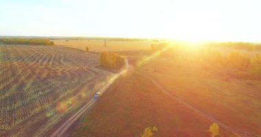 UHD 4K hava görüntüsü. Sarı kırsal alan ve toprak yol üzerinde orta-uçuş