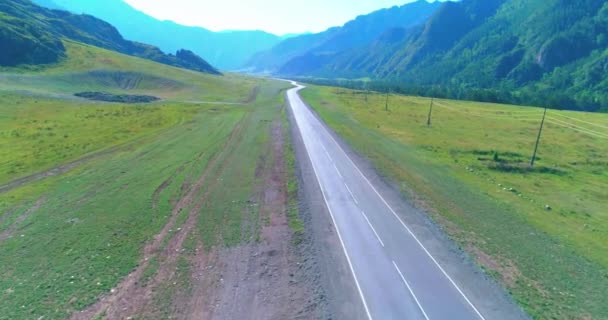 Vuelo sobre carretera asfaltada montaña carretera y prado — Vídeo de stock