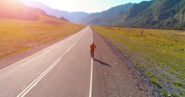 Tiefflug hinter sportlichem Mann auf perfekter Asphaltstraße — Stockvideo