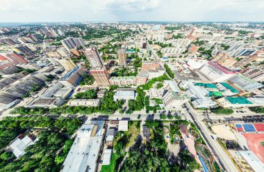 Kesişen yollar, evler, binalar, parklar ve otoparklar olan havacılık şehri manzarası. Güneşli yaz panoramik resmi