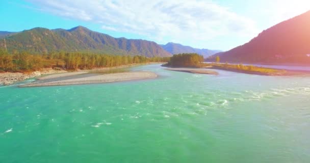 Vista aérea 4k UHD. Vuelo bajo sobre el río fresco de montaña fría en la soleada mañana de verano. Árboles verdes y rayos de sol en horisont — Vídeos de Stock