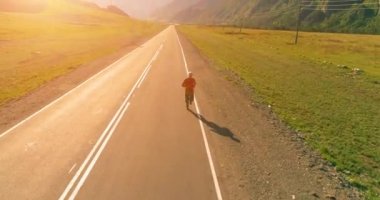 Mükemmel asfalt yolda sporcunun önünde alçak irtifa uçuşu.