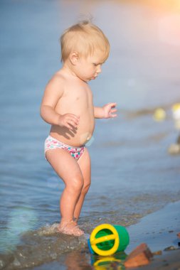Şirin Bebek kumlu plajı ve deniz suyu oynarken.