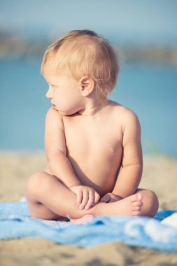 Şirin Bebek denize yakın kum plajındaki oyuncaklar ile oynama.