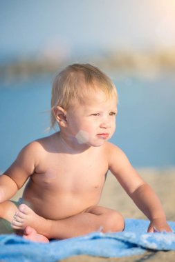 Şirin Bebek denize yakın kum plajındaki oyuncaklar ile oynama.
