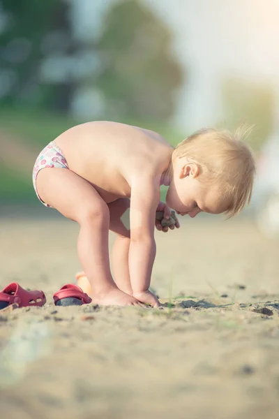 Słodkie dziecko grając z zabawkami na piaszczystej plaży w pobliżu morza. — Zdjęcie stockowe