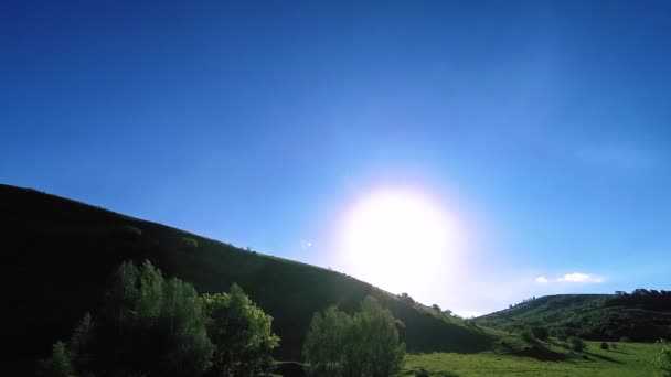 4K UHD montaña prado timelapse en el verano. Nubes, árboles, hierba verde y rayos de sol movimiento. — Vídeos de Stock