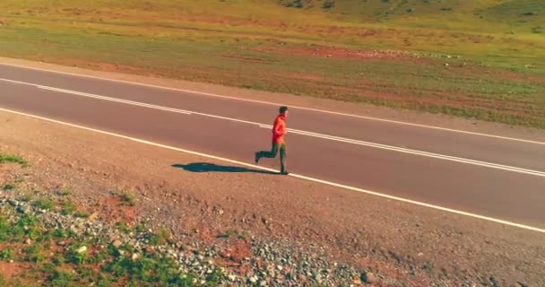 Vuelo de baja altitud frente al deportista en el camino perfecto de asfalto — Vídeo de stock