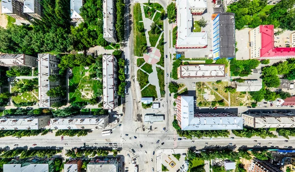 Vista aérea de la ciudad con encrucijadas y caminos, casas, edificios, parques y estacionamientos. Imagen panorámica soleada de verano —  Fotos de Stock