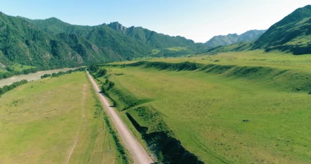 Camino de montaña rural aéreo y prado en la soleada mañana de verano. Autopista del asfalto y río. — Vídeo de stock
