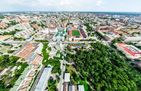 Uitzicht op de stad vanuit de lucht met kruispunten en wegen, huizen, gebouwen, parken en parkeerplaatsen. Zonnige zomer panoramisch beeld — Stockfoto