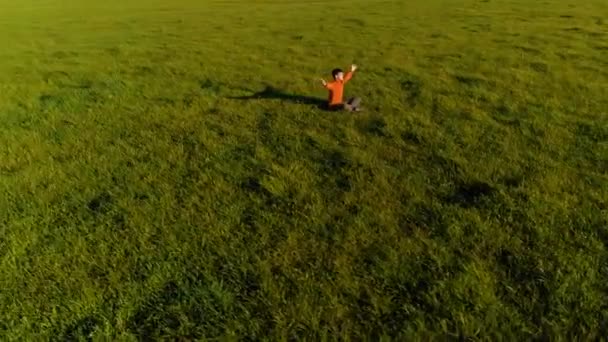 Penerbangan ketinggian rendah radial di atas olahraga pria yoga di rumput hijau yang sempurna. Matahari terbenam di gunung. — Stok Video