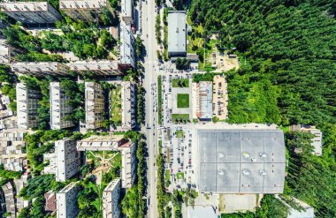 Kesişen yollar, evler, binalar, parklar ve otoparklar olan havacılık şehri manzarası. Güneşli yaz panoramik resmi
