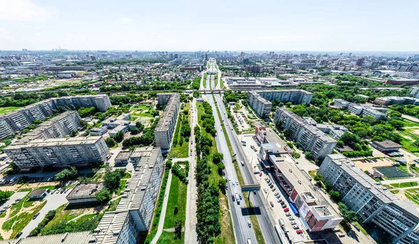 Kesişen yollar, evler, binalar, parklar ve otoparklar olan havacılık şehri manzarası. Güneşli yaz panoramik resmi