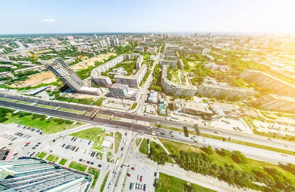 Vista aérea de la ciudad con encrucijadas y caminos, casas, edificios, parques y estacionamientos. Imagen panorámica soleada de verano —  Fotos de Stock