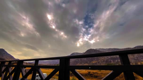 Тімелапс дерев'яного паркану на високій терасі в гірському пейзажі з хмарами. Горизонтальний рух повзунка — стокове відео