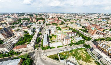 Kesişen yollar, evler, binalar, parklar ve otoparklar olan havacılık şehri manzarası. Güneşli yaz panoramik resmi