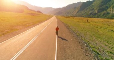 Mükemmel asfalt yol, sportif adamın arkasında alçak irtifa uçuş