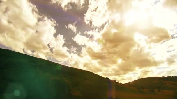 4K UHD górska łąka timelapse w lecie. Chmury, drzewa, zielona trawa i promieniowanie słoneczne. — Wideo stockowe