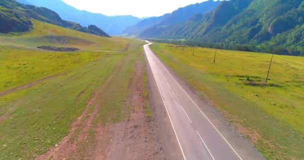 Vuelo sobre carretera asfaltada montaña carretera y prado — Vídeos de Stock