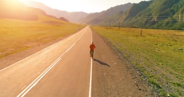 Tiefflug hinter sportlichem Mann auf perfekter Asphaltstraße — Stockvideo