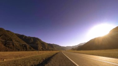 Yaz ya da sonbahar günbatımında gün batımında dağ yolu zamanı. Vahşi doğa ve kırsal alan.