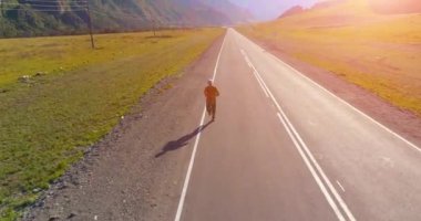 Mükemmel asfalt yolda sporcunun önünde alçak irtifa uçuşu.