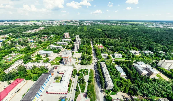 Letecký výhled na město s křižovatkou a silnic, domů, budov, parků a parkovišť. Slunečné léto panoramatický obraz — Stock fotografie