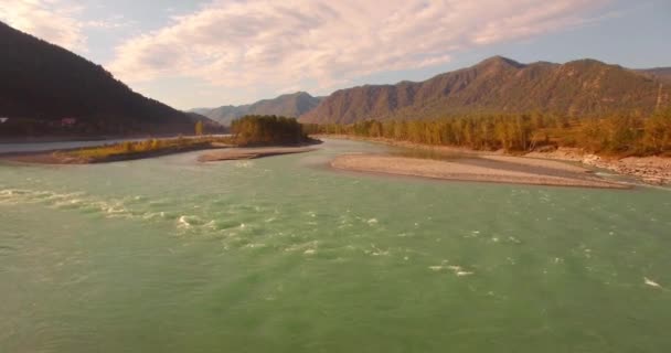 Vista aérea 4k UHD. Vuelo bajo sobre el río fresco de montaña fría en la soleada mañana de verano. Árboles verdes y rayos de sol en horisont — Vídeo de stock