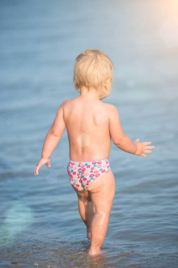 Şirin Bebek kumlu plajı ve deniz suyu oynarken.