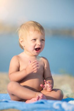 Şirin Bebek denize yakın kum plajındaki oyuncaklar ile oynama.