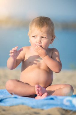 Şirin Bebek denize yakın kum plajındaki oyuncaklar ile oynama.
