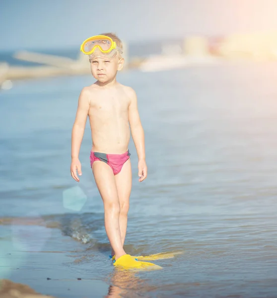 Lindo niño pequeño con máscara y aletas para bucear en la playa tropical de arena . — Foto de Stock