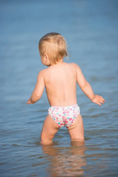 Carino bambino che gioca sulla spiaggia di sabbia e in acqua di mare . — Foto Stock