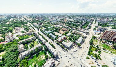 Kesişen yollar, evler, binalar, parklar ve otoparklar olan havacılık şehri manzarası. Güneşli yaz panoramik resmi