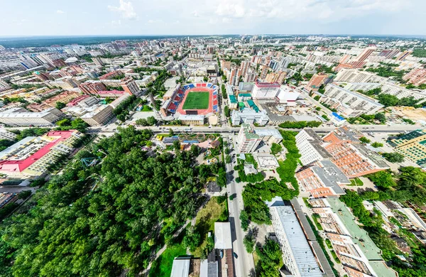 Vista aérea de la ciudad con encrucijadas y caminos, casas, edificios, parques y estacionamientos. Imagen panorámica soleada de verano — Foto de Stock