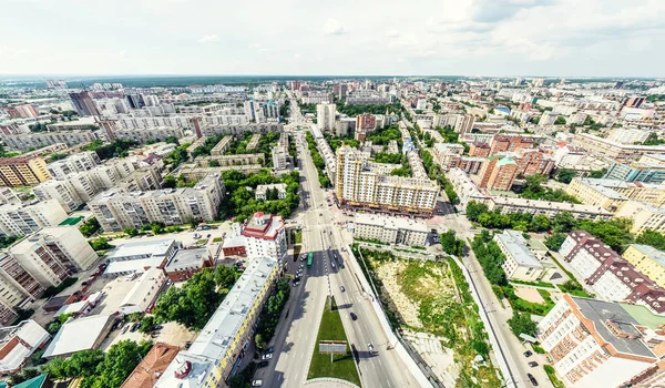 Kesişen yollar, evler, binalar, parklar ve otoparklar olan havacılık şehri manzarası. Güneşli yaz panoramik resmi
