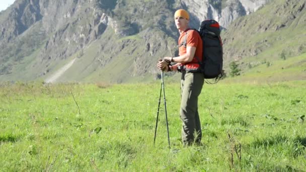 Piesze wycieczki man walking na góry zielony łąka z plecaka. Koncepcja lato sport i rekreacja. — Wideo stockowe